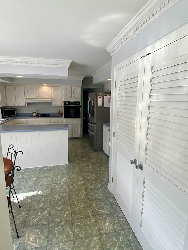 kitchen featuring under cabinet range hood, stainless steel fridge with ice dispenser, ornamental molding, and oven