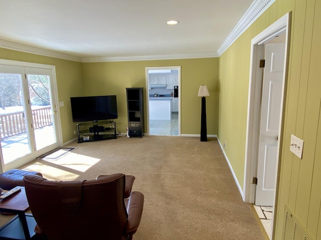 living area with light colored carpet, visible vents, crown molding, and baseboards