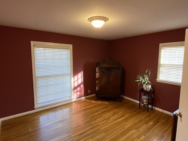 interior space with baseboards, visible vents, and wood finished floors