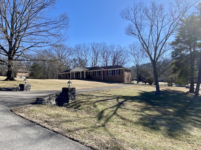 view of front of home with a front yard and brick siding