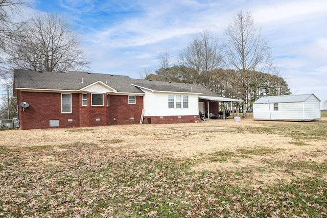 rear view of house with brick siding, a storage unit, crawl space, a carport, and an outdoor structure