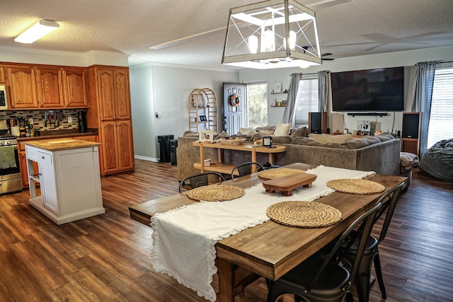 dining space featuring ornamental molding, plenty of natural light, and dark wood finished floors