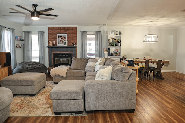 living room featuring ornamental molding, a brick fireplace, dark wood-style flooring, and plenty of natural light