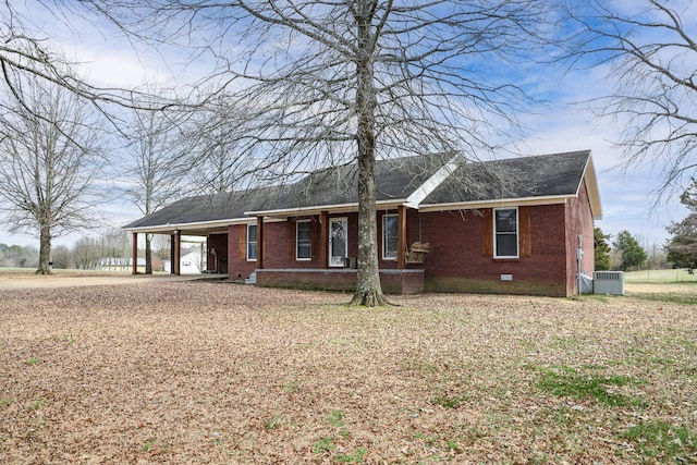 ranch-style home featuring brick siding, crawl space, cooling unit, and an attached carport