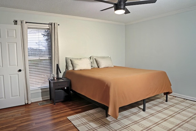 bedroom with crown molding, a textured ceiling, baseboards, and wood finished floors