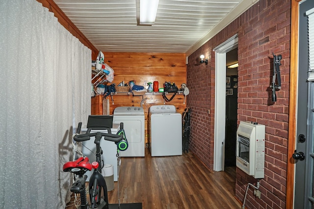 laundry room with laundry area, dark wood finished floors, brick wall, heating unit, and washer and dryer