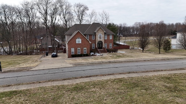 georgian-style home with a front yard and brick siding