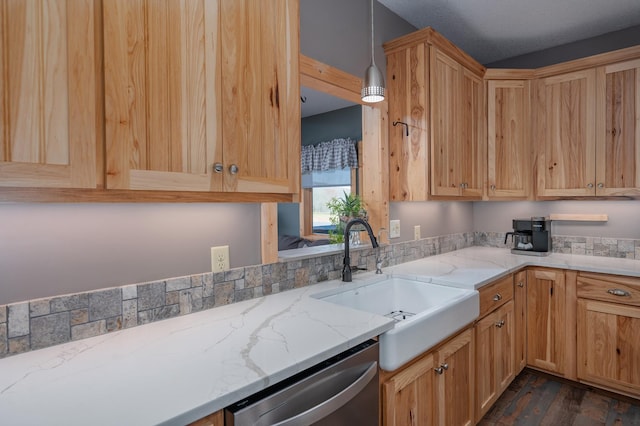 kitchen with light stone counters, dark wood-style flooring, decorative light fixtures, a sink, and stainless steel dishwasher