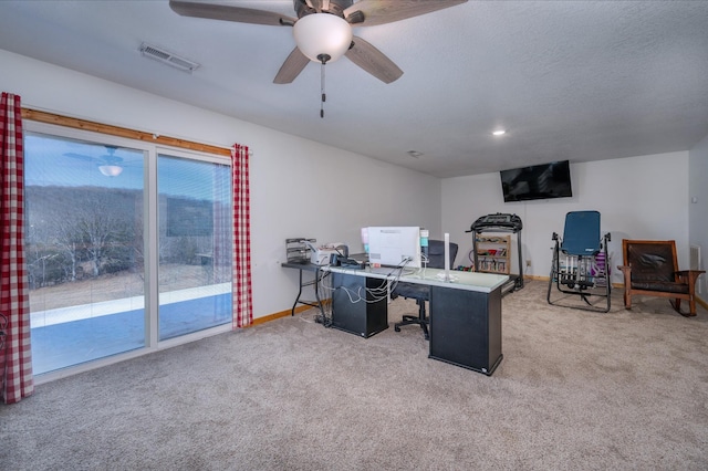 carpeted office with a textured ceiling, a ceiling fan, visible vents, and baseboards