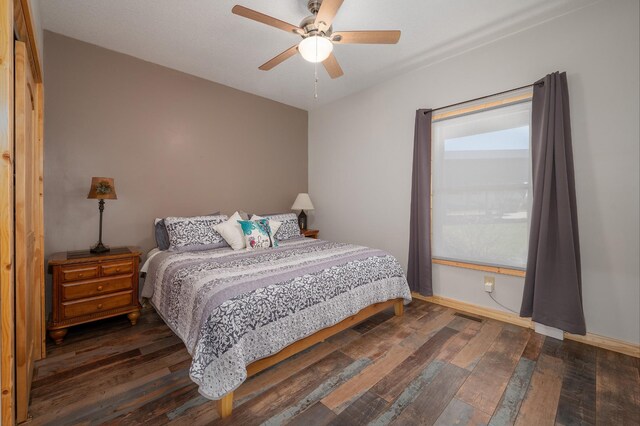 bedroom with dark wood-type flooring, baseboards, and a ceiling fan