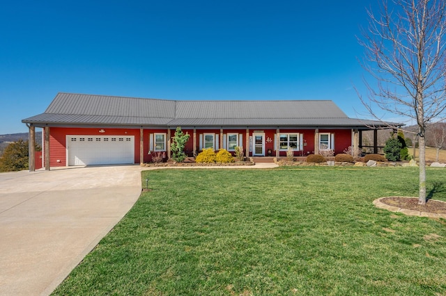 ranch-style home with metal roof, an attached garage, concrete driveway, a standing seam roof, and a front yard