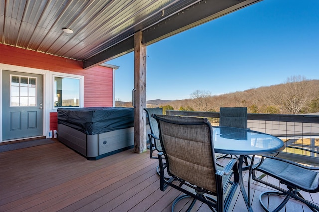 deck with outdoor dining space and a mountain view