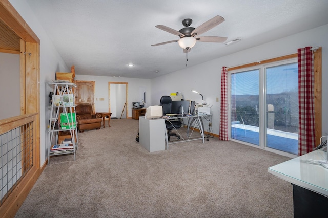 home office with carpet floors, visible vents, a textured ceiling, and a ceiling fan