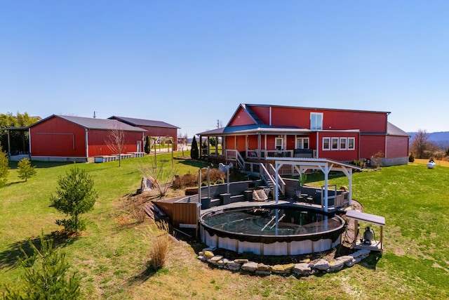 rear view of property with a covered pool, a lawn, and an outdoor structure