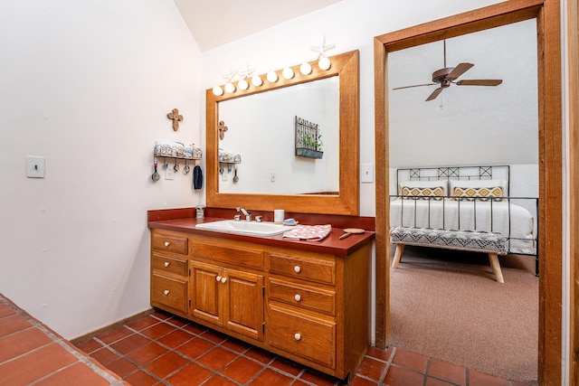 ensuite bathroom featuring ceiling fan, ensuite bath, tile patterned floors, vaulted ceiling, and vanity