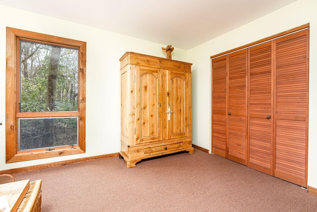 unfurnished bedroom featuring carpet floors, a closet, and baseboards