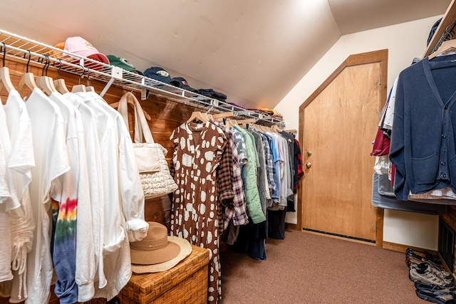 walk in closet with carpet floors and lofted ceiling