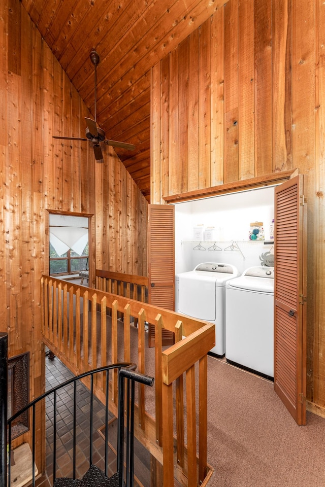 interior space with carpet, vaulted ceiling, wood walls, wooden ceiling, and independent washer and dryer