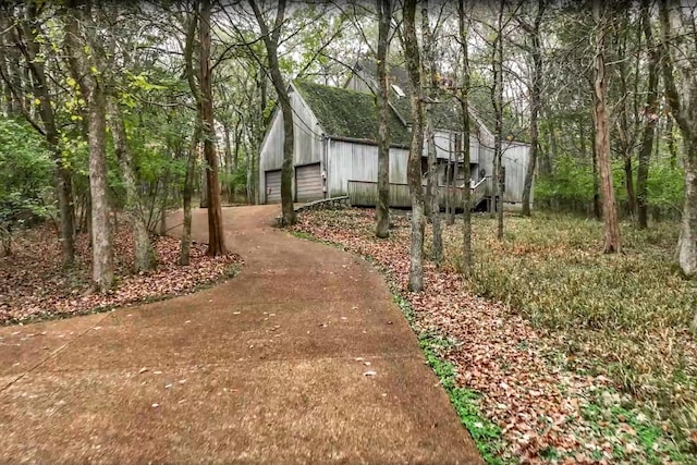 view of side of property featuring board and batten siding and a detached garage