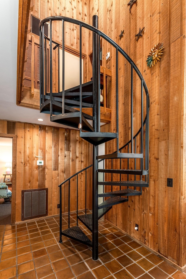 stairs featuring visible vents and wooden walls