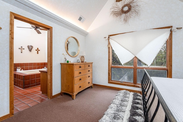 bedroom with lofted ceiling, visible vents, dark carpet, and ensuite bathroom