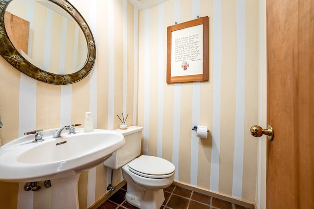 half bathroom featuring baseboards, tile patterned floors, toilet, and wallpapered walls