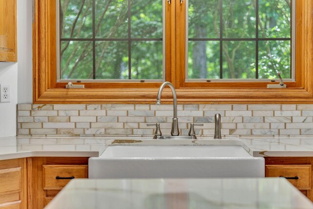 735 Keytown Rd, Portland, TN 37148 - kitchen view of a sink, tasteful backsplash, brown cabinetry, and light stone counters