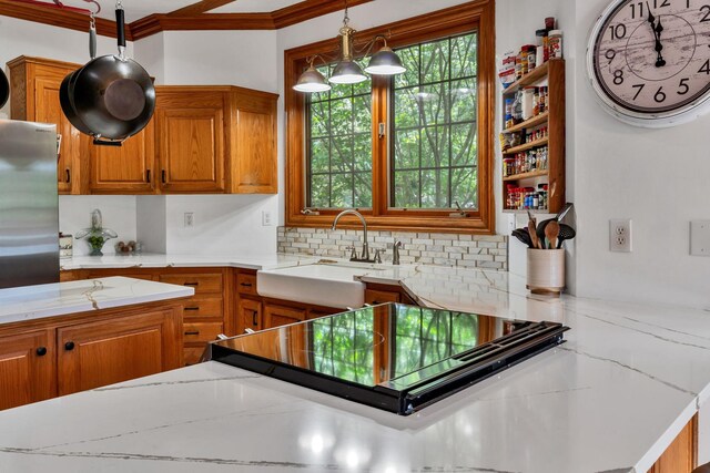 735 Keytown Rd, Portland, TN 37148 - kitchen featuring a sink, brown cabinetry, ornamental molding, light stone countertops, and hanging light fixtures