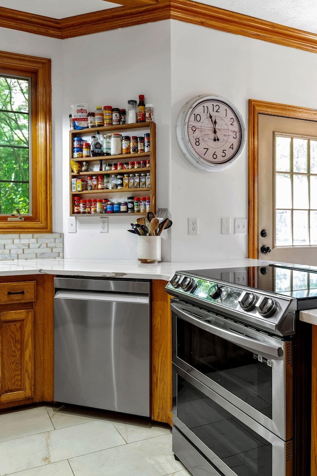 735 Keytown Rd, Portland, TN 37148 - kitchen featuring appliances with stainless steel finishes, crown molding, brown cabinetry, light countertops, and light tile patterned floors