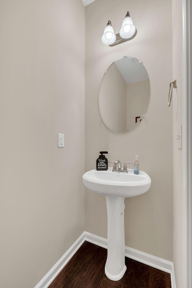 bathroom featuring a sink, baseboards, and wood finished floors