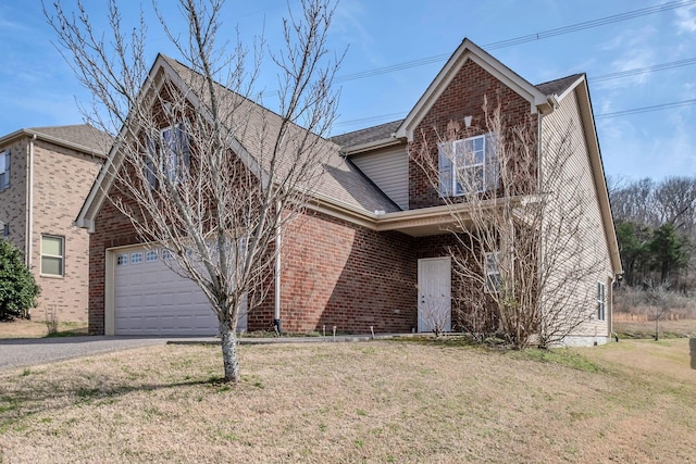 traditional-style house featuring brick siding, a front lawn, a shingled roof, and aphalt driveway