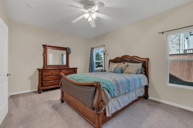 bedroom featuring light carpet, ceiling fan, and baseboards