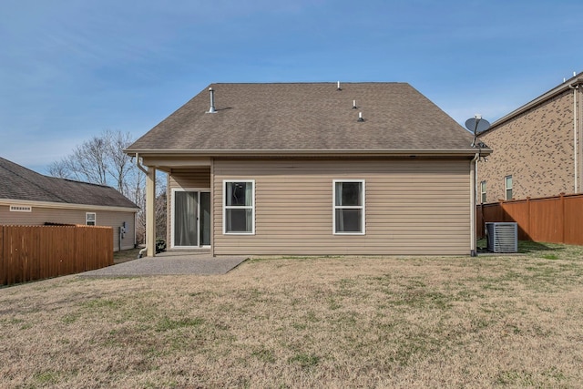 back of property featuring a yard, roof with shingles, and fence