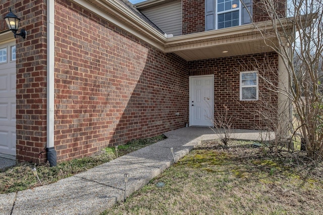 property entrance featuring brick siding and an attached garage