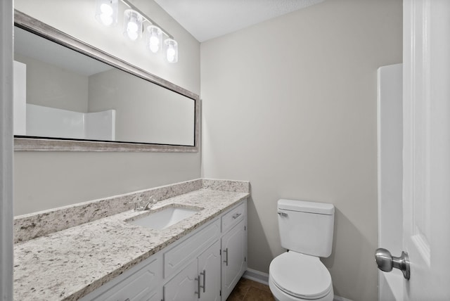 bathroom featuring tile patterned flooring, baseboards, vanity, and toilet