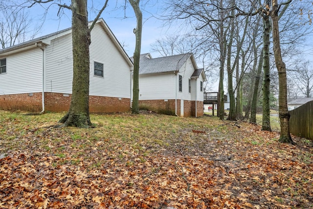 view of side of home with a deck and crawl space