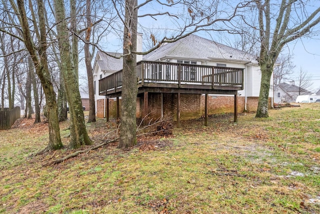 back of house with a lawn and a deck