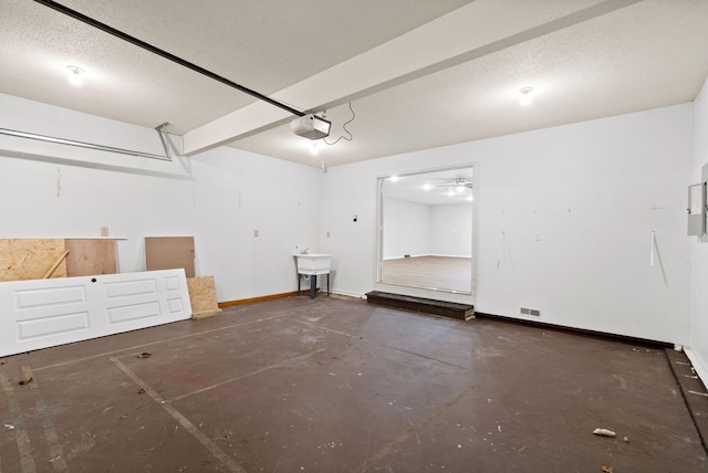 garage with baseboards, a sink, and a garage door opener