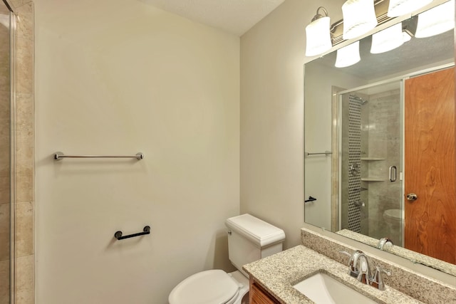 bathroom featuring a stall shower, vanity, and toilet