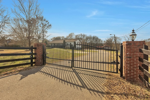 view of gate featuring fence and a lawn