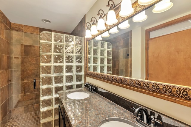 full bathroom featuring a walk in shower, double vanity, and a sink