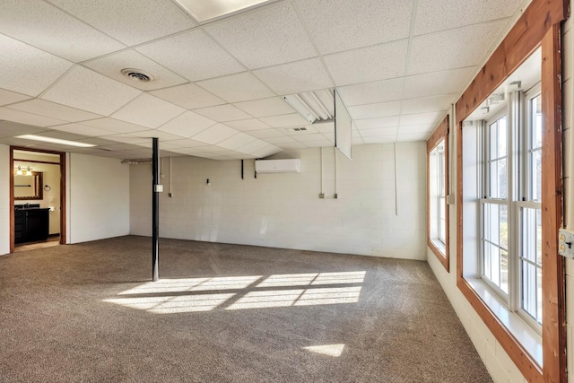 unfurnished room with a wall mounted AC, carpet flooring, visible vents, and a healthy amount of sunlight