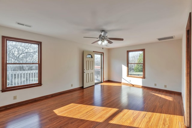 spare room with baseboards, visible vents, ceiling fan, and wood finished floors