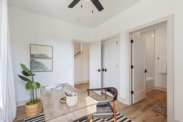 home office with baseboards, ceiling fan, and light wood-style floors