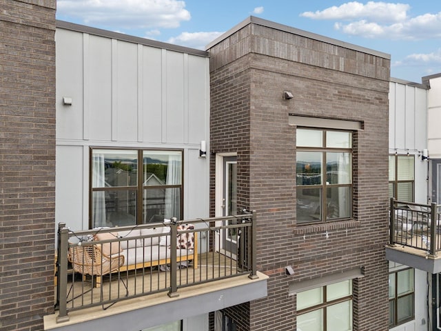 view of front of house with brick siding and a balcony