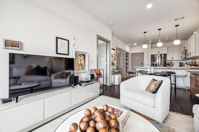 living room featuring light wood-type flooring, visible vents, and recessed lighting