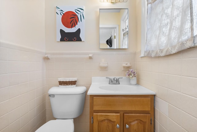 bathroom featuring toilet, a wainscoted wall, and vanity