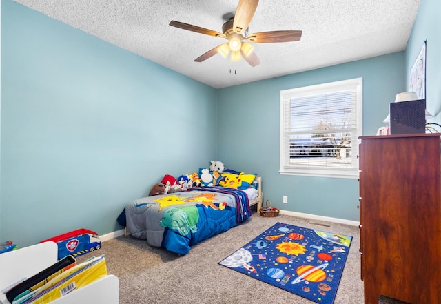 bedroom with a textured ceiling, ceiling fan, carpet flooring, and baseboards