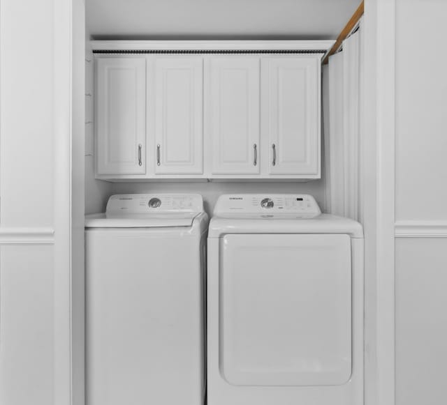 washroom featuring cabinet space and washing machine and clothes dryer