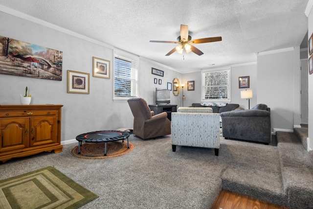 living area featuring baseboards, ceiling fan, ornamental molding, carpet, and a textured ceiling